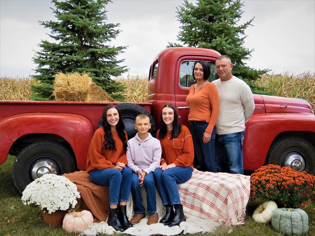 Tom Stidham and his family with a vintage red pickup truck