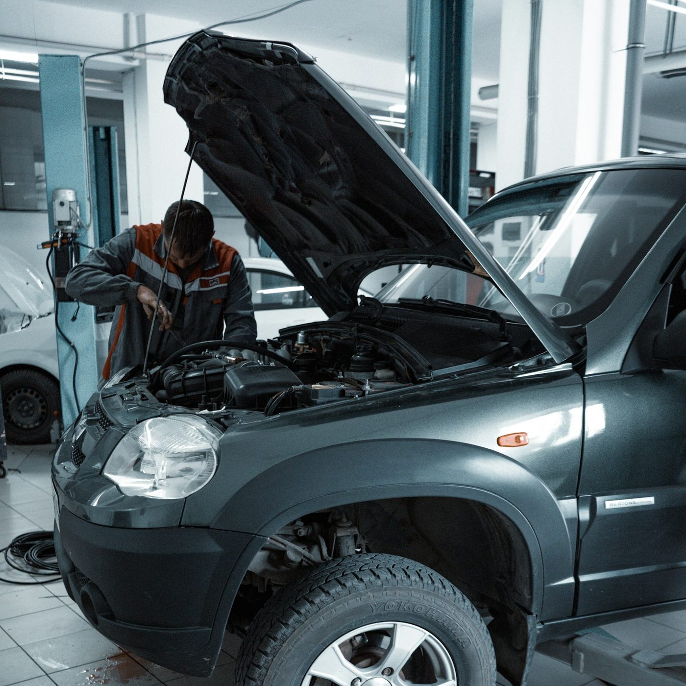 Mechanic working under the hood in a service bay
